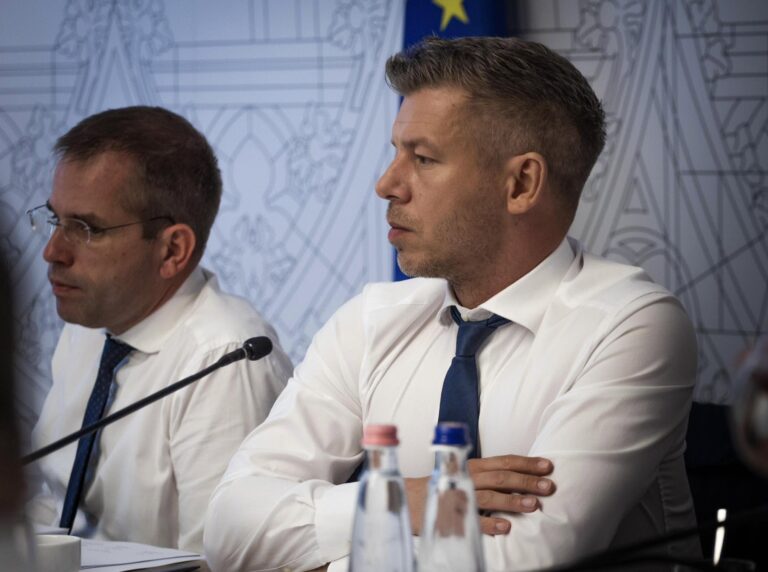 Premier Węgier Péter Magyar podczas konferencji prasowej z członkiem rządu, obaj w białych koszulach i granatowych krawatach